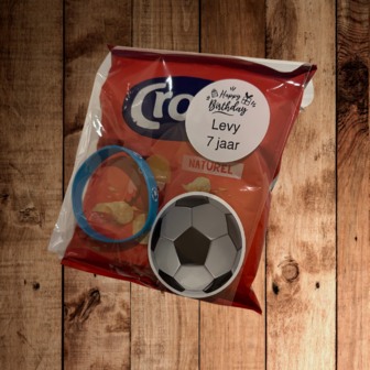 Chips zakje met daarbij een vinyl sticker en een armband met voetballen erop